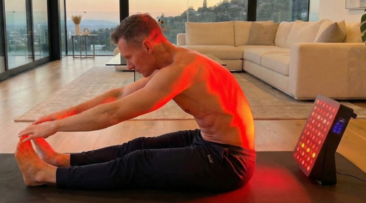A man performing stretches while using the Fresh Healthcare CORE red light core device to support muscle recovery, demonstrating the superior coverage of LED panels over standard red lamps
