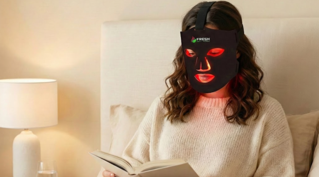 Woman reading in bed using the Fresh Healthcare LED Face Mask to help improve the appearance of skin texture and tone
